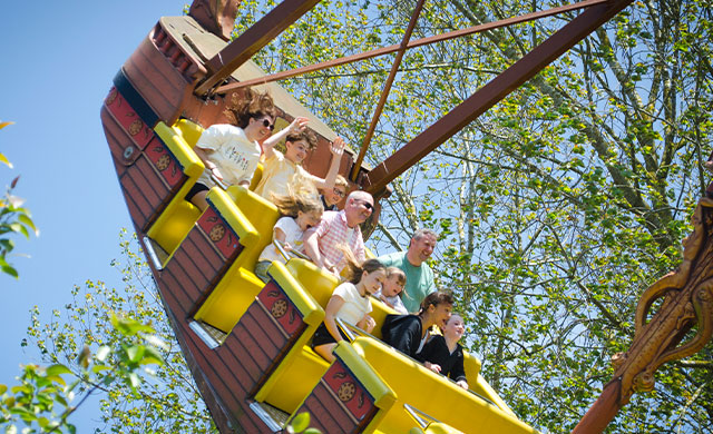 Families on pirate ship theme park ride